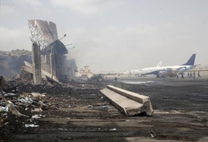 Planes are seen near a section of a damaged building at Jinnah International Airport, after Sunday's attack by Taliban militants, in Karachi